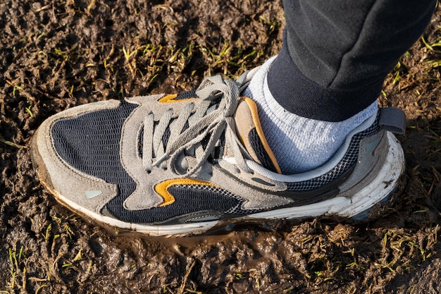 Las zapatillas del hombre pisan el pantano Zapatillas en el pantano