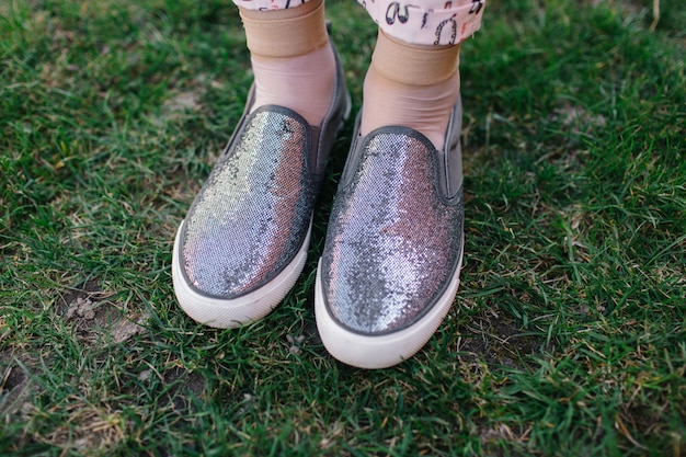 Zapatillas de mujer grises con destellos. Resbalón en los pies. zapatos brillantes