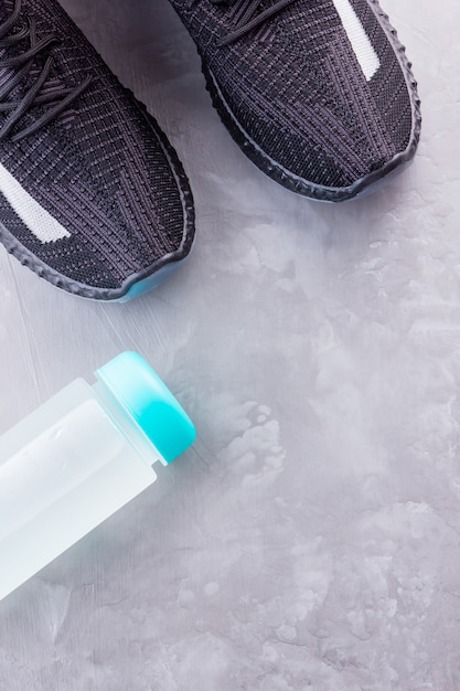 Zapatillas negras y una botella de agua.