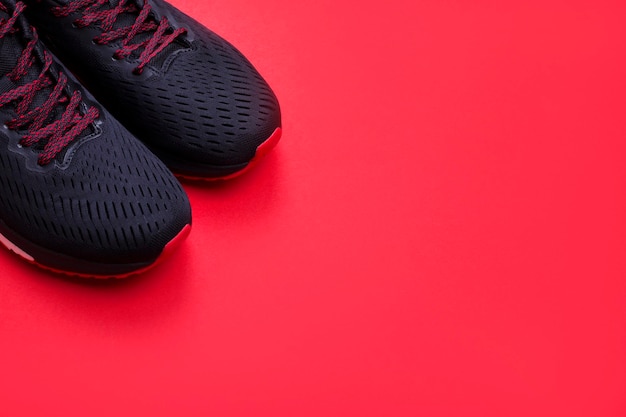 Zapatillas negras sobre un fondo rojo brillante El concepto de un estilo de vida saludable Vista desde arriba