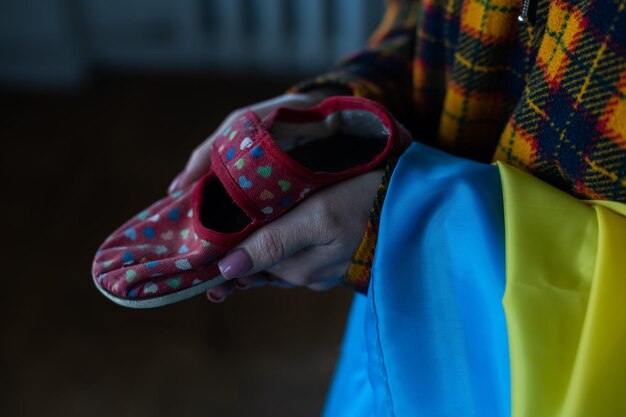 Zapatillas para niños en manos de las madres. Guerra en Ucrania.