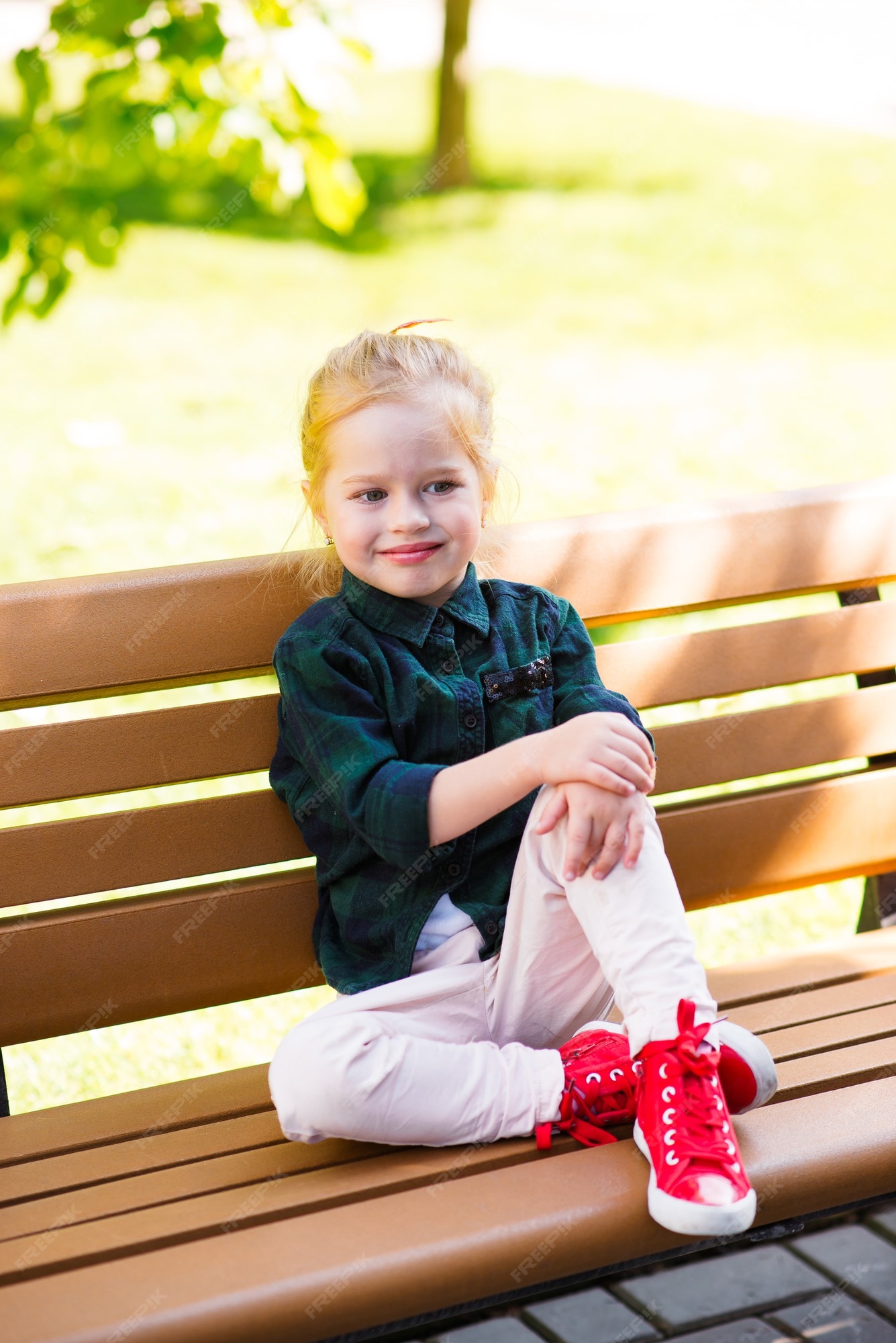 Zapatillas rojas hermosas de niña delgada con zapatos rojos y falda de jean | Foto Premium