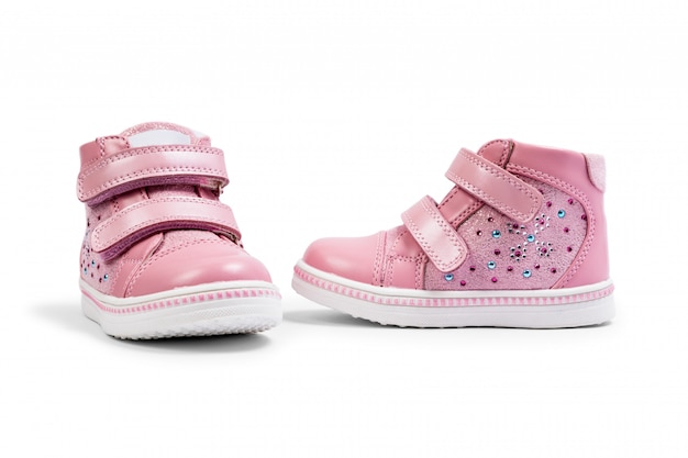 Las zapatillas rosa para niños aisladas.