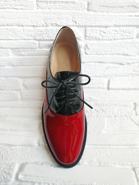 Zapato de mujer de charol negro y rojo sobre un fondo blanco, vista superior. Zapatos elegantes de mujer.