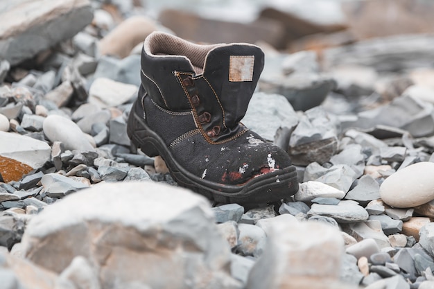 Un zapato en la orilla entre las piedras