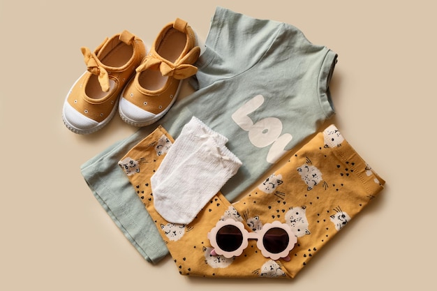 Zapatos y accesorios de ropa para niños con estilo sobre fondo beige plano