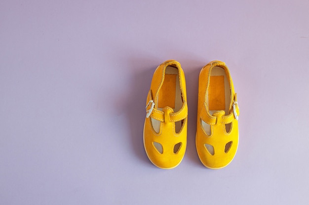 Foto zapatos de bebé de color amarillo brillante en una lila