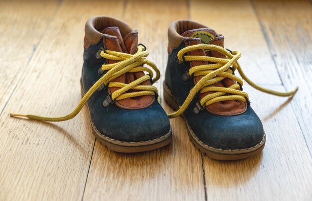 Zapatos de bebé en madera vista de cerca botas de niño de color azul y amarillo