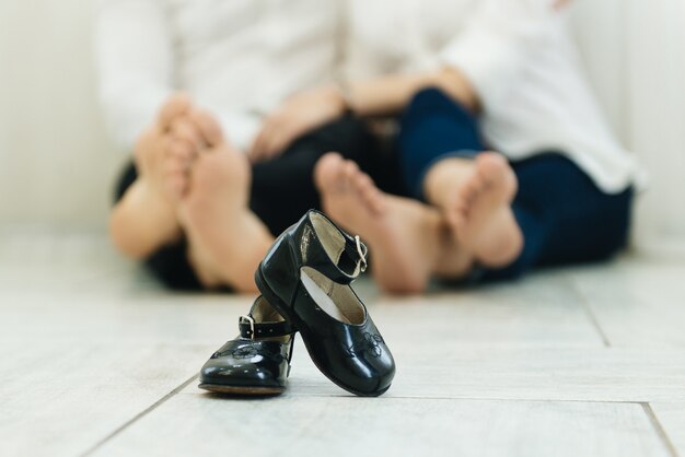 Zapatos de bebé niño con pies descalzos padres