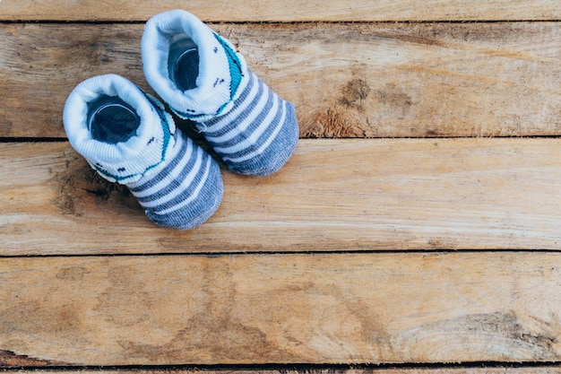 Zapatos de bebé sobre fondo de madera con espacio