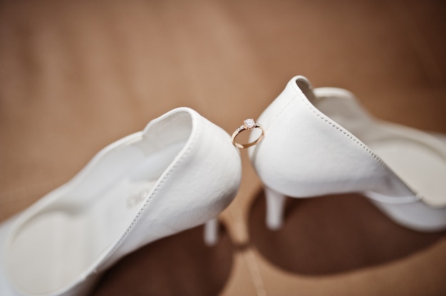 Zapatos blancos elegantes de la boda en la mañana de la novia.