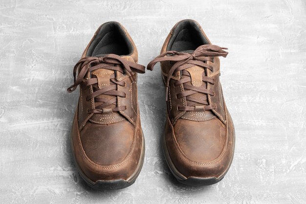 Zapatos para caminar de cuero marrón para hombre sobre fondo texturizado