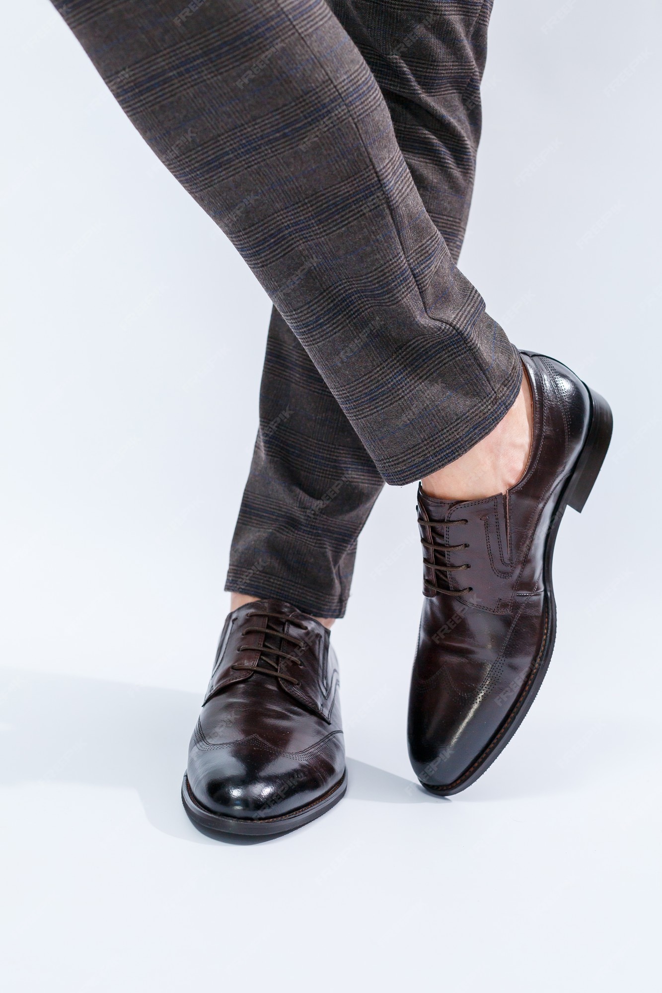 Zapatos clásicos de piel natural, de hombre debajo de un traje clásico. | Foto Premium