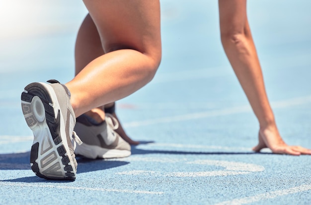 Foto zapatos para correr y comenzar con una deportista o una corredora en una pista para un ejercicio de entrenamiento o entrenamiento fitness run y cardio con un atleta preparándose para una competencia o carrera al aire libre