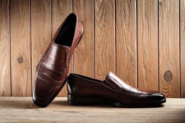 Zapatos de cuero marrón para hombres zapatos de cuero de lujo sobre fondo de madera