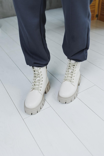 Zapatos de cuero de mujer Piernas femeninas en botas de cuero beige Botas de mujer de moda