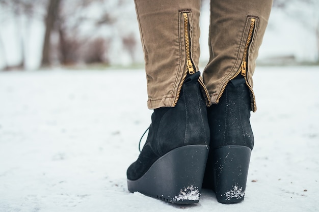 Zapatos femeninos en una plataforma en la nieve, vista trasera