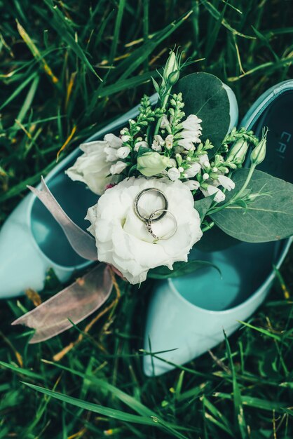 Zapatos con flores y anillos en la hierba