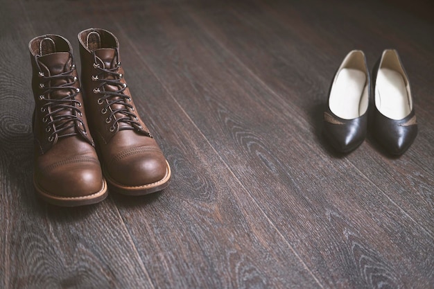 Zapatos de hombre y mujer hechos de cuero sobre un piso de madera Dos pares de zapatos antiguos