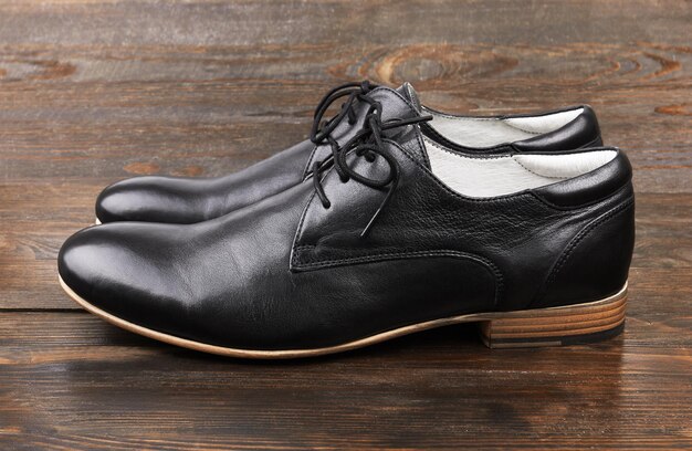 Zapatos de hombre negros en madera.