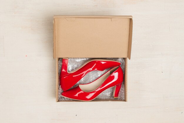 Foto zapatos de mujer con estilo en una caja sobre mesa de madera.