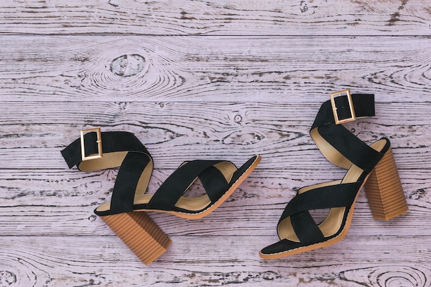 Foto zapatos de mujer negros para el verano en un piso de madera.