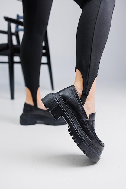 Zapatos de mujer Primer plano de piernas femeninas en polainas negras y mocasines de cuero negro Nueva colección primavera-verano de zapatos de cuero para mujer