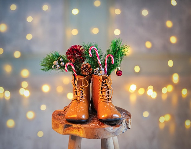 Zapatos de Navidad en un fondo de madera entre regalos y velas