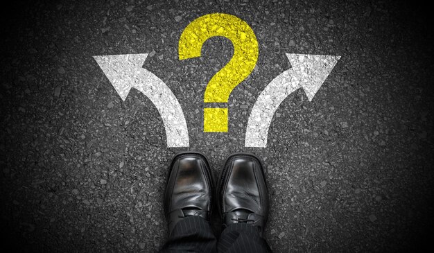 Zapatos de negocios negros dos flechas y concepto de problema de signo de interrogación