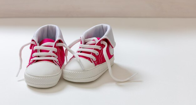 Zapatos de niña de bebé en fondo de color blanco en primer plano