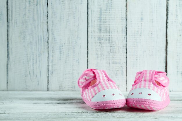 Zapatos de niño rosa sobre fondo de madera