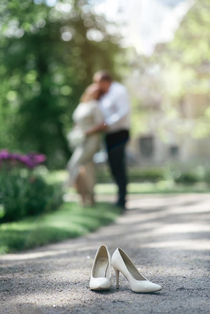 Los zapatos de la novia en el fondo borroso de los recién casados