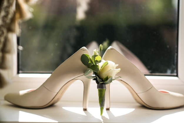 Zapatos de novias con flor en el fondo de la ventana