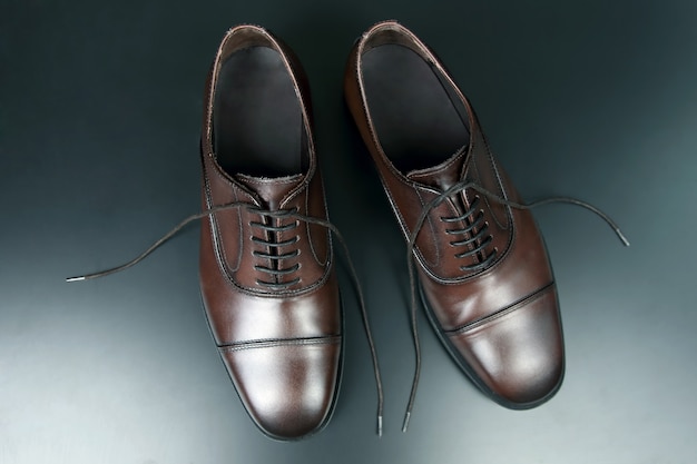 Zapatos Oxford marrones para hombre clásicos en la oscuridad.