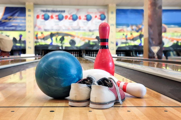 Foto zapatos de pelota y pasadores en el suelo en el club de bolos