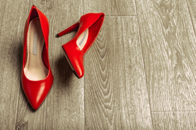 Zapatos rojos de mujer en piso de madera
