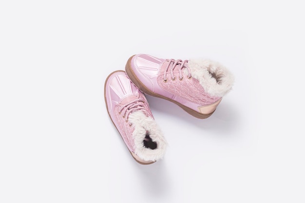 Zapatos rosas para niños sobre un fondo blanco Vista superior plana