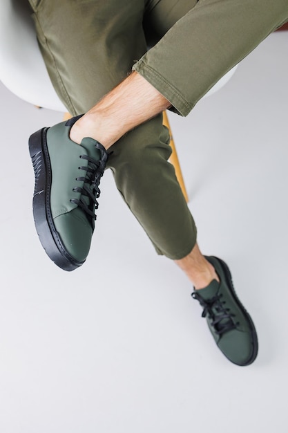 Zapatos de verano Primer plano de piernas masculinas en pantalones verdes y zapatillas de deporte casuales verdes Zapatos de cuero de verano para hombres