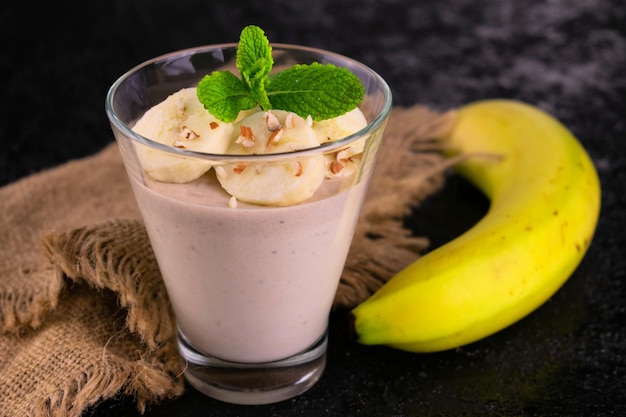 Zarte Bananenmousse mit Nüssen auf schwarzem Hintergrund Nahaufnahme