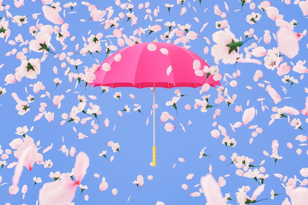 Zarte Blüten, die auf rosa Regenschirm vor blauem Hintergrund fallen