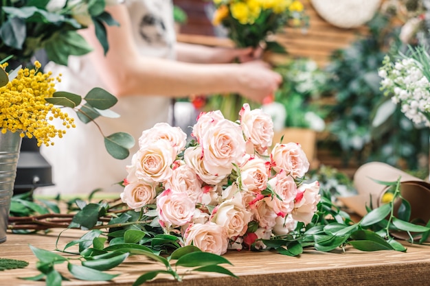 Zarte Rosen auf Arbeitsschreibtisch des Floristen