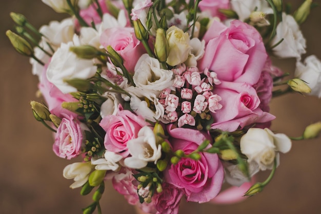Zarter Strauß rosa und weißer Blumen in den Händen der Braut 214