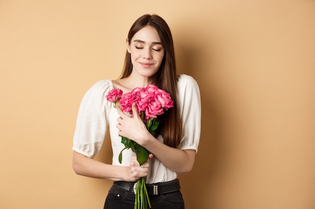 Zartes und romantisches Mädchen, Rosen riechen und mit geschlossenen Augen lächeln.