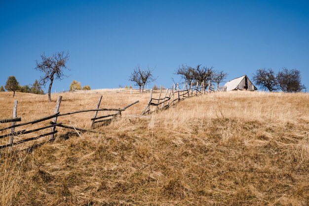 Foto zaun auf dem feld gegen den klaren blauen himmel