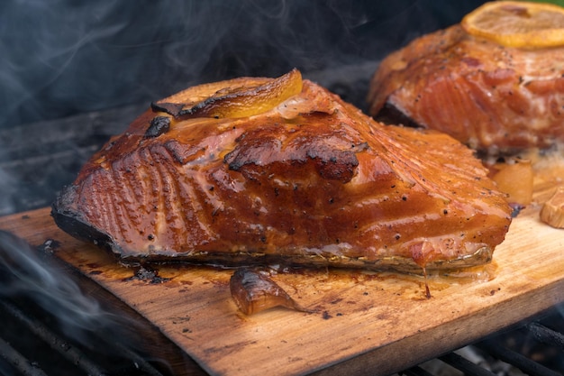 Zedernplankenlachs mit Zitrone, die auf Grill kocht