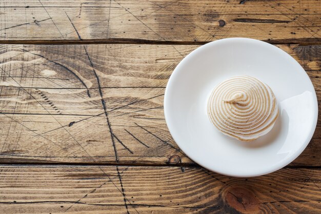 Zéfiro do marshmallow da baunilha com caramelo em uma tabela de madeira.