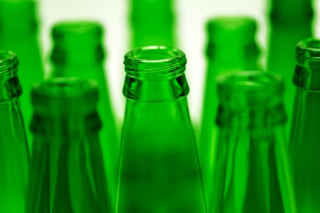 Zehn grüne leere Bierflaschen erschossen. Eine zentrale Flaschen im Fokus.