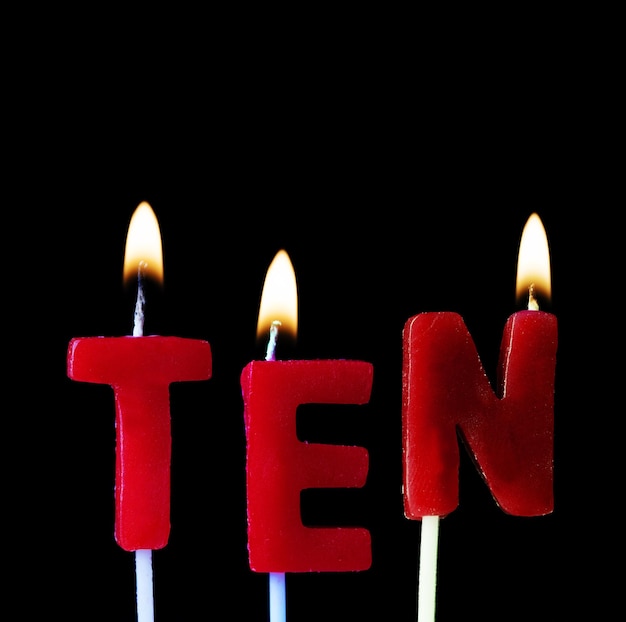 Zehn rote Geburtstagskerzen auf schwarzem Hintergrund