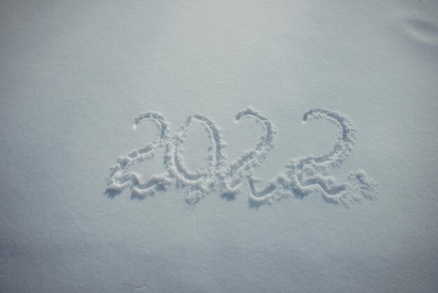 Zeichnen auf weißem Schnee. Neujahr, Zahlen 2022, Nahaufnahme.