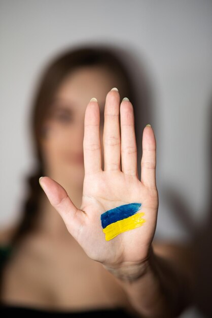 Zeichnung der ukrainischen Flagge auf der Hand einer Frau kein Krieg